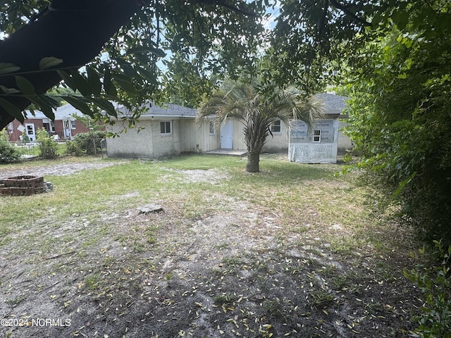 view of yard with a fire pit and fence