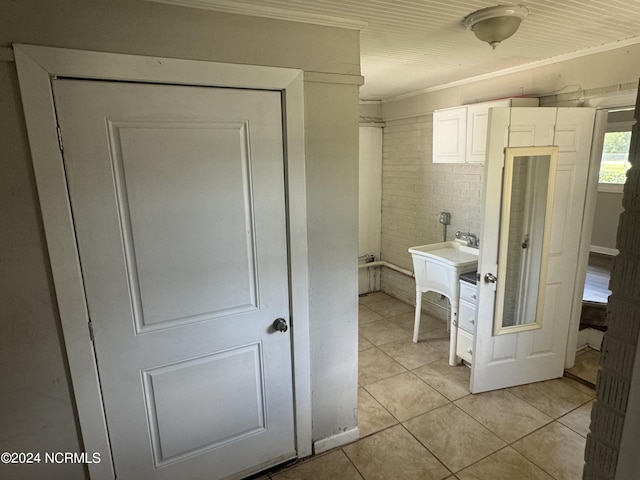 bathroom with ornamental molding and tile patterned floors