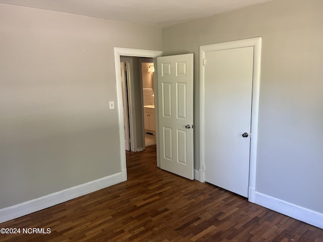 unfurnished bedroom featuring dark wood finished floors and baseboards