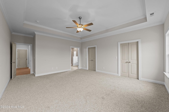 unfurnished bedroom with ceiling fan, crown molding, and a tray ceiling