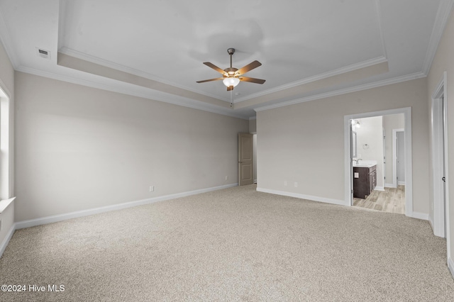 unfurnished bedroom with ceiling fan, a raised ceiling, and crown molding