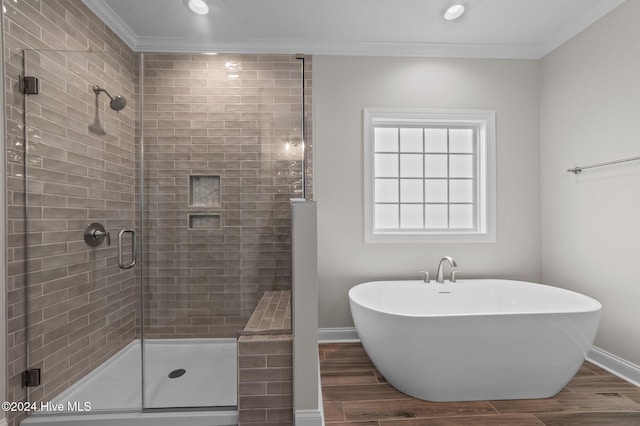 bathroom with hardwood / wood-style floors, crown molding, and plus walk in shower