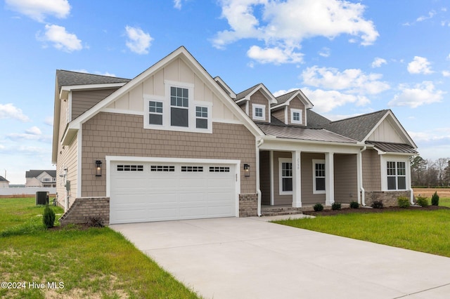 craftsman house featuring cooling unit, a garage, and a front yard