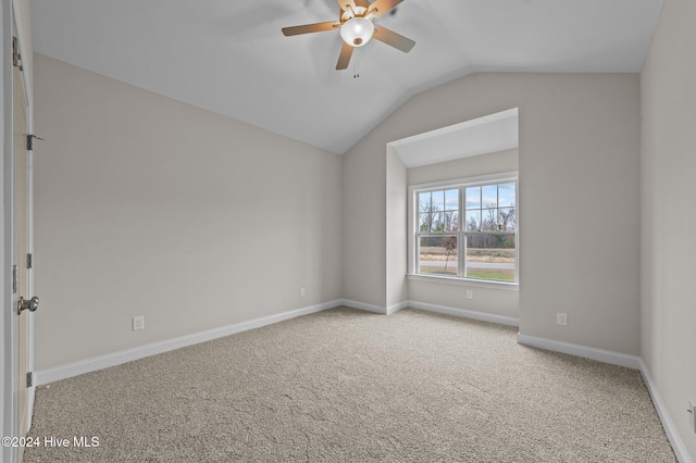 carpeted empty room featuring vaulted ceiling and ceiling fan