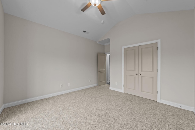 unfurnished bedroom with ceiling fan, lofted ceiling, carpet floors, and a closet