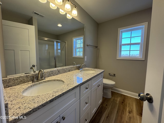 bathroom with wood-type flooring, toilet, a shower with door, and vanity