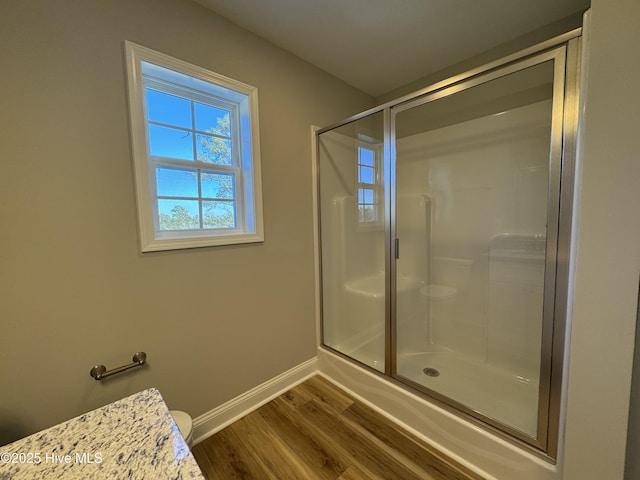 bathroom with a shower with shower door and wood-type flooring