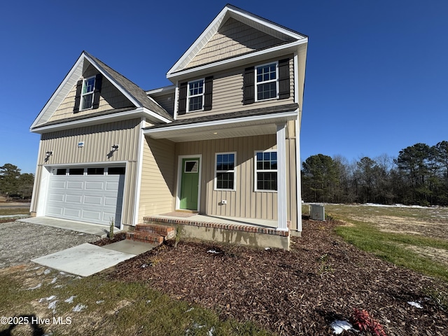 view of front of house featuring covered porch, central AC unit, and a garage