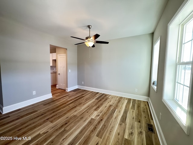 unfurnished room with ceiling fan and wood-type flooring