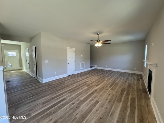 unfurnished living room with dark hardwood / wood-style floors and ceiling fan