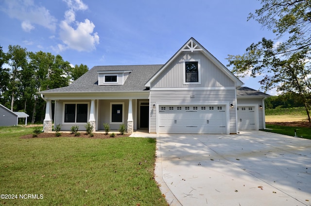 view of front of house with concrete driveway, roof with shingles, a front lawn, a porch, and board and batten siding