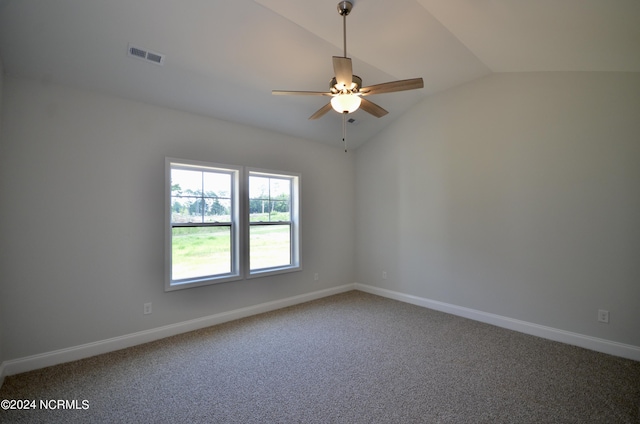 carpeted spare room featuring lofted ceiling, baseboards, visible vents, and a ceiling fan