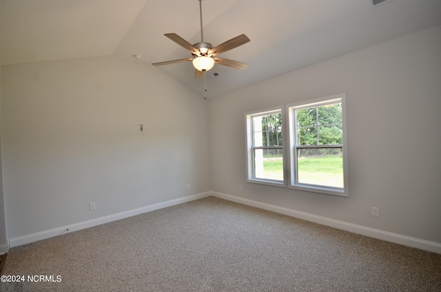 empty room featuring lofted ceiling, ceiling fan, light carpet, and baseboards