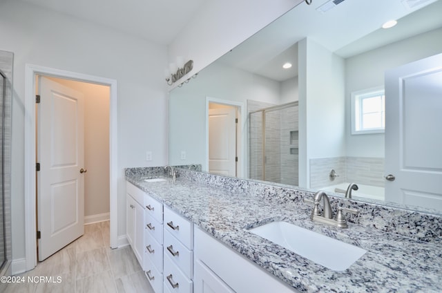 full bath with a stall shower, visible vents, a sink, and double vanity