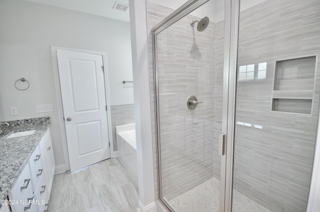 bathroom featuring a shower stall, visible vents, a bath, and vanity