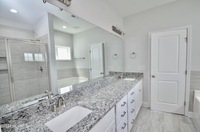 full bath featuring a garden tub, a sink, and a shower stall