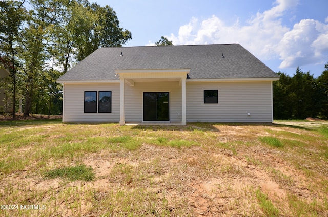 back of house featuring roof with shingles