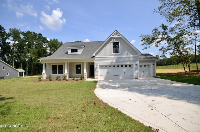 view of front of house with driveway, roof with shingles, a front lawn, a porch, and board and batten siding