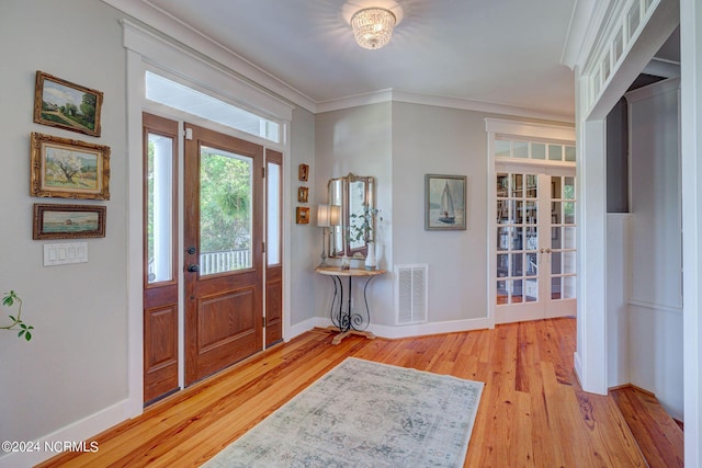 foyer with crown molding and light wood-type flooring