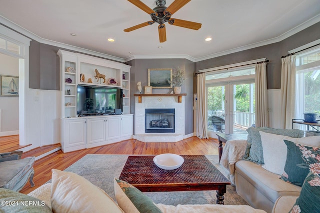 living room with ceiling fan, light wood-type flooring, ornamental molding, and french doors