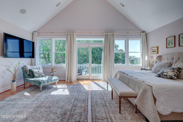 bedroom with hardwood / wood-style floors, access to outside, and vaulted ceiling