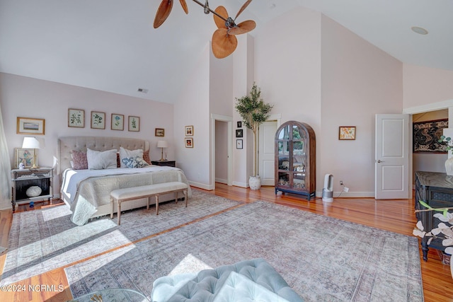 bedroom with ceiling fan, high vaulted ceiling, and light hardwood / wood-style floors