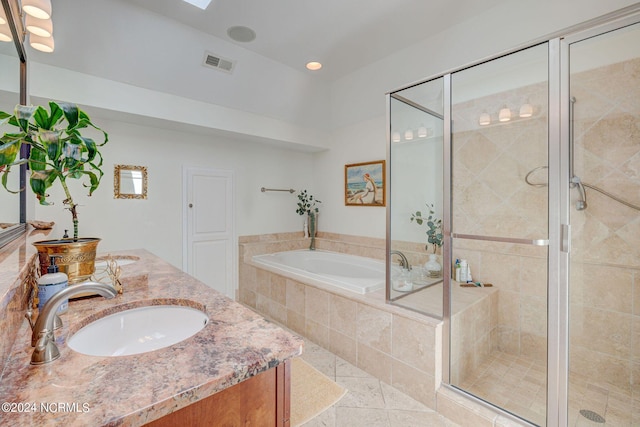 bathroom featuring plus walk in shower, vanity, and tile patterned flooring