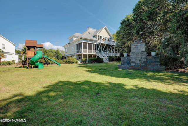 view of yard with a sunroom and a playground