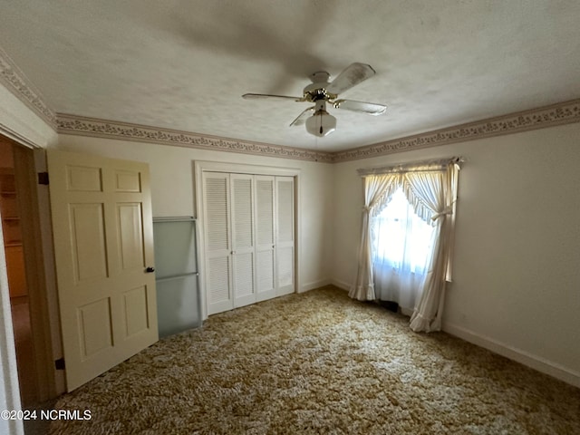 unfurnished bedroom featuring carpet, ceiling fan, a textured ceiling, and a closet