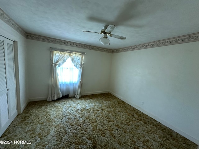 empty room with ceiling fan, carpet floors, and a textured ceiling