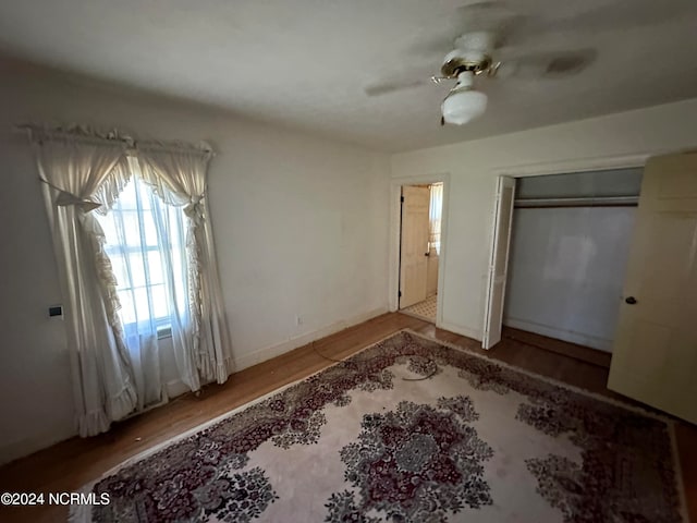 unfurnished bedroom featuring ceiling fan, a closet, and hardwood / wood-style flooring