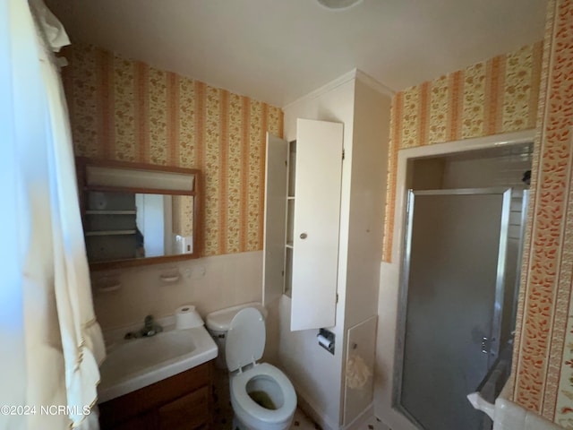 bathroom featuring vanity, toilet, and a shower with shower door