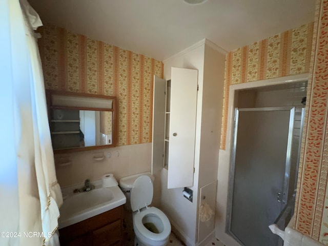 bathroom featuring vanity, a shower with shower door, and toilet