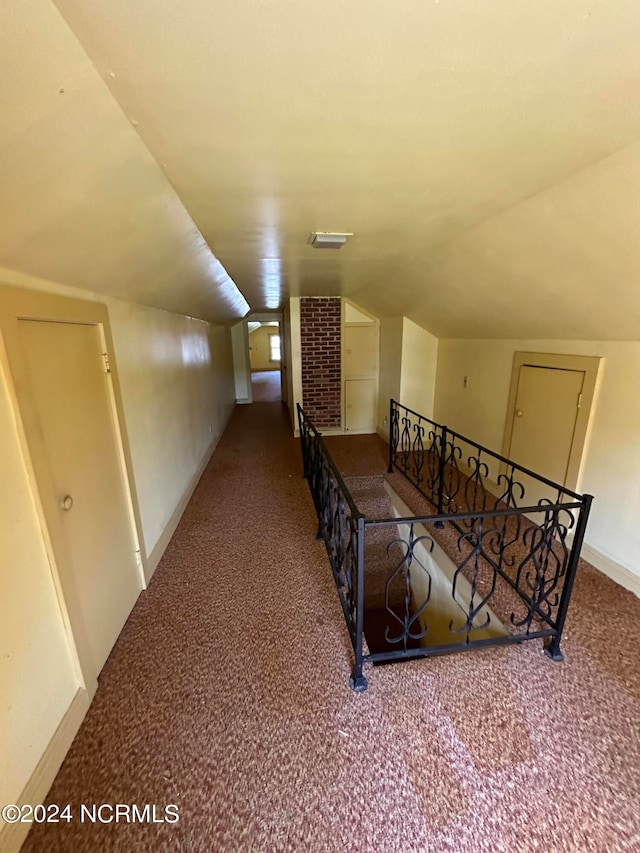 corridor featuring carpet and lofted ceiling