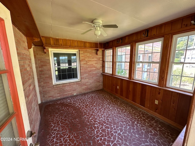 unfurnished sunroom with ceiling fan