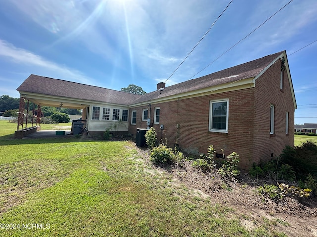 back of property featuring a lawn