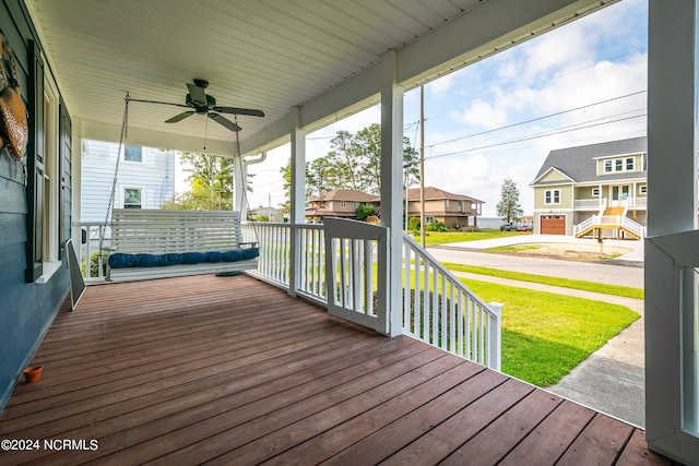 deck featuring a porch, a lawn, and ceiling fan