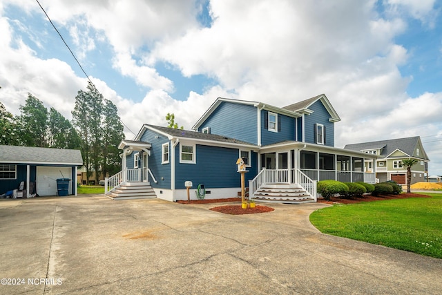 519 E Water St, Belhaven, NC 27810 - view of front facade with a sunroom, driveway, an outbuilding, crawl space, and a front yard