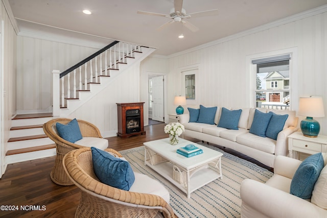 living room featuring dark wood-type flooring, crown molding, a fireplace, and ceiling fan