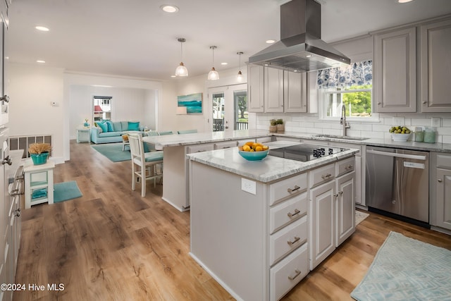 kitchen featuring a wealth of natural light, stainless steel dishwasher, a kitchen island, and island range hood