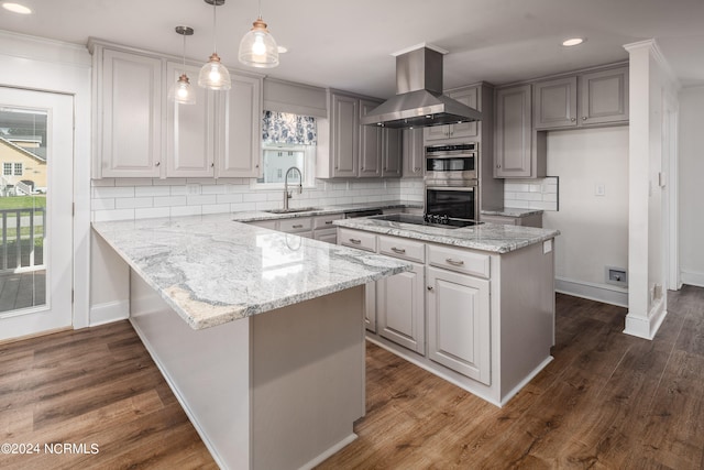 kitchen with dark wood-type flooring, hanging light fixtures, exhaust hood, and stainless steel double oven