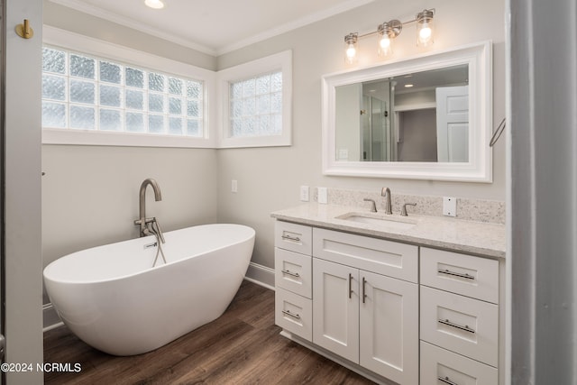 bathroom featuring vanity, a bathtub, ornamental molding, and hardwood / wood-style floors