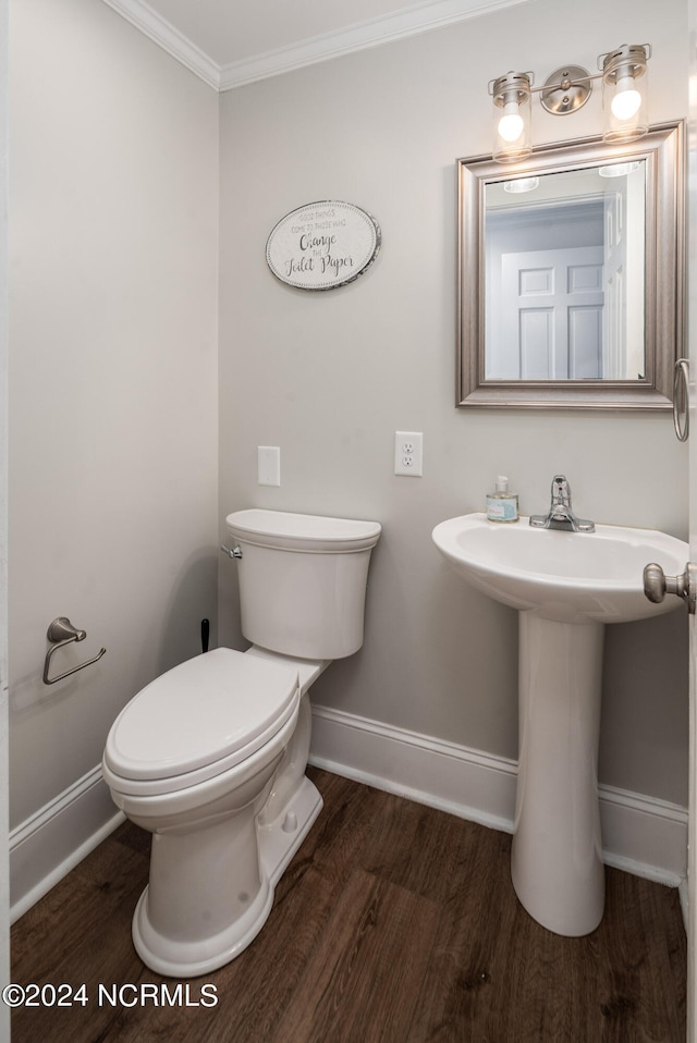 bathroom featuring toilet, ornamental molding, sink, and hardwood / wood-style floors