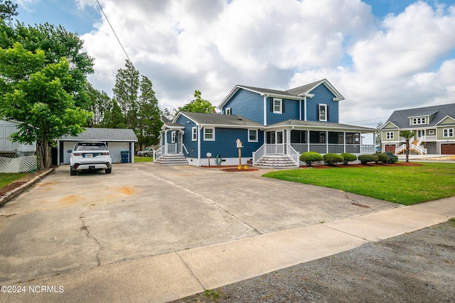 view of front of property with a garage, an outdoor structure, and a front lawn