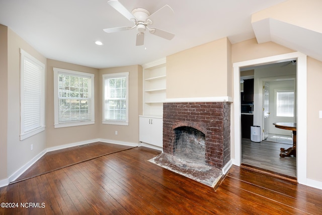 unfurnished living room featuring baseboards, wood-type flooring, a fireplace, and built in features