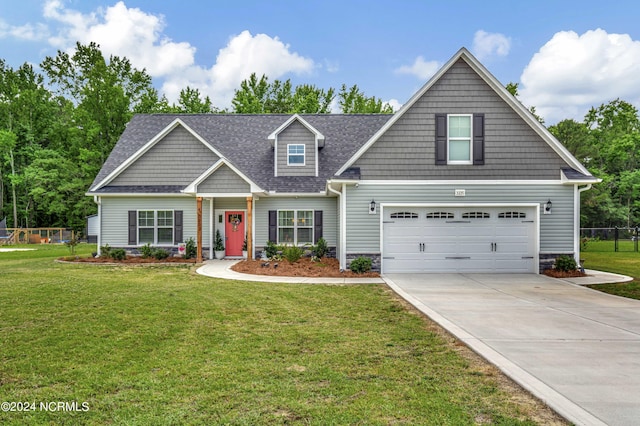 craftsman inspired home with a garage and a front lawn