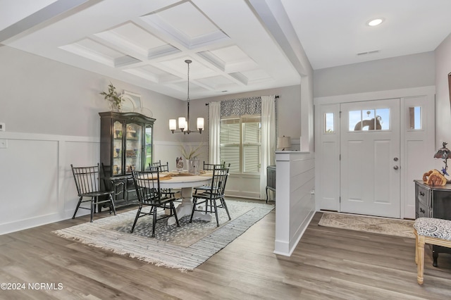 dining room with beamed ceiling, coffered ceiling, a chandelier, and hardwood / wood-style floors