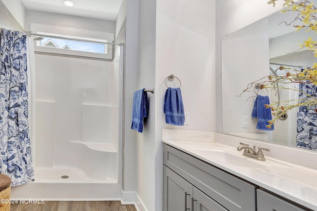 bathroom with vanity, wood-type flooring, and walk in shower