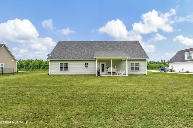 rear view of property featuring a yard and a patio