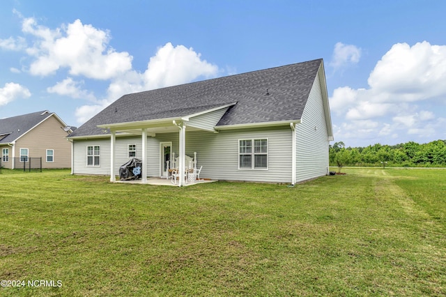 rear view of house featuring a yard and a patio area